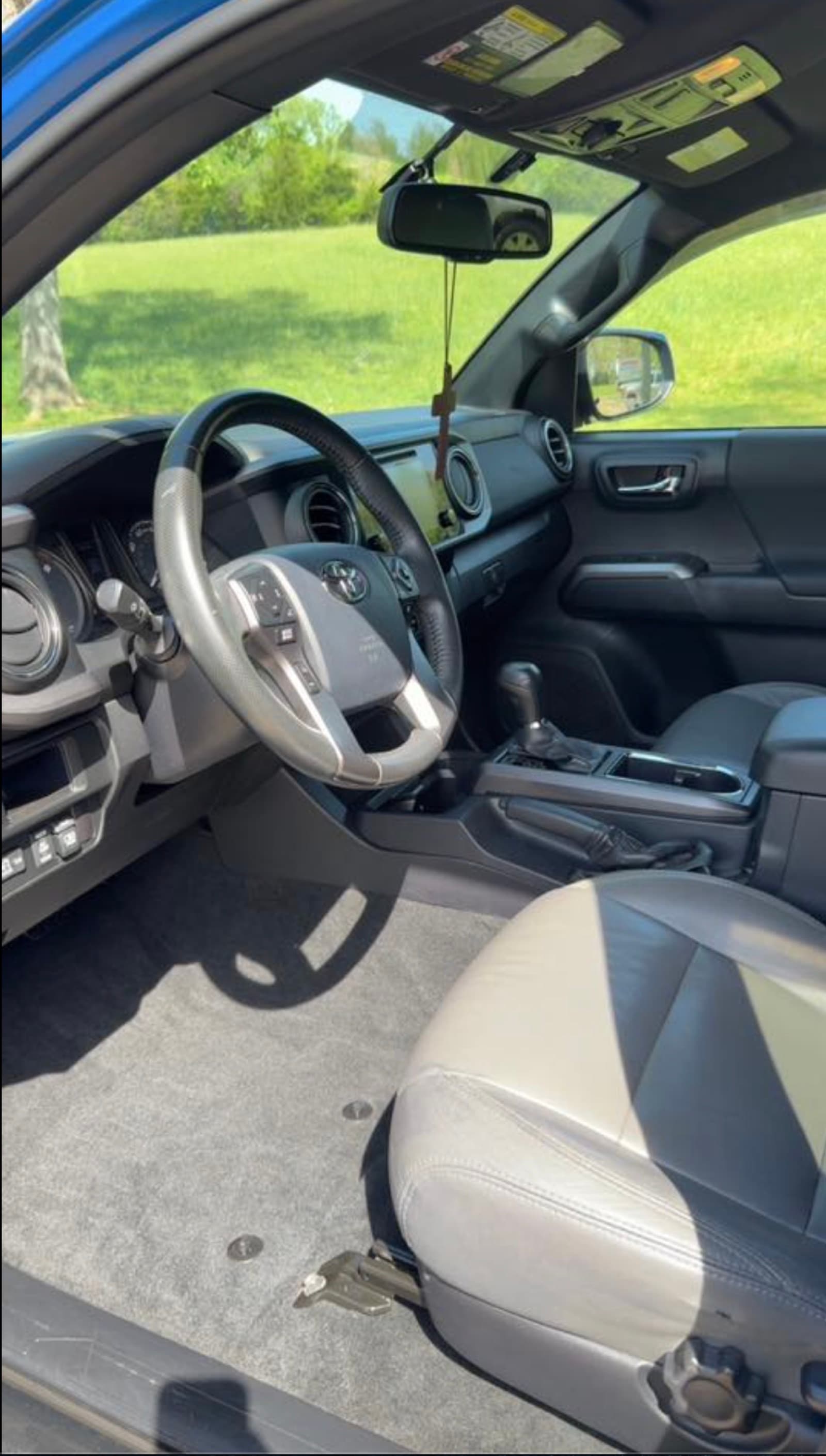 Toyota Tacoma interior after deep clean — clean floor mat, polished leather, clean steering wheel