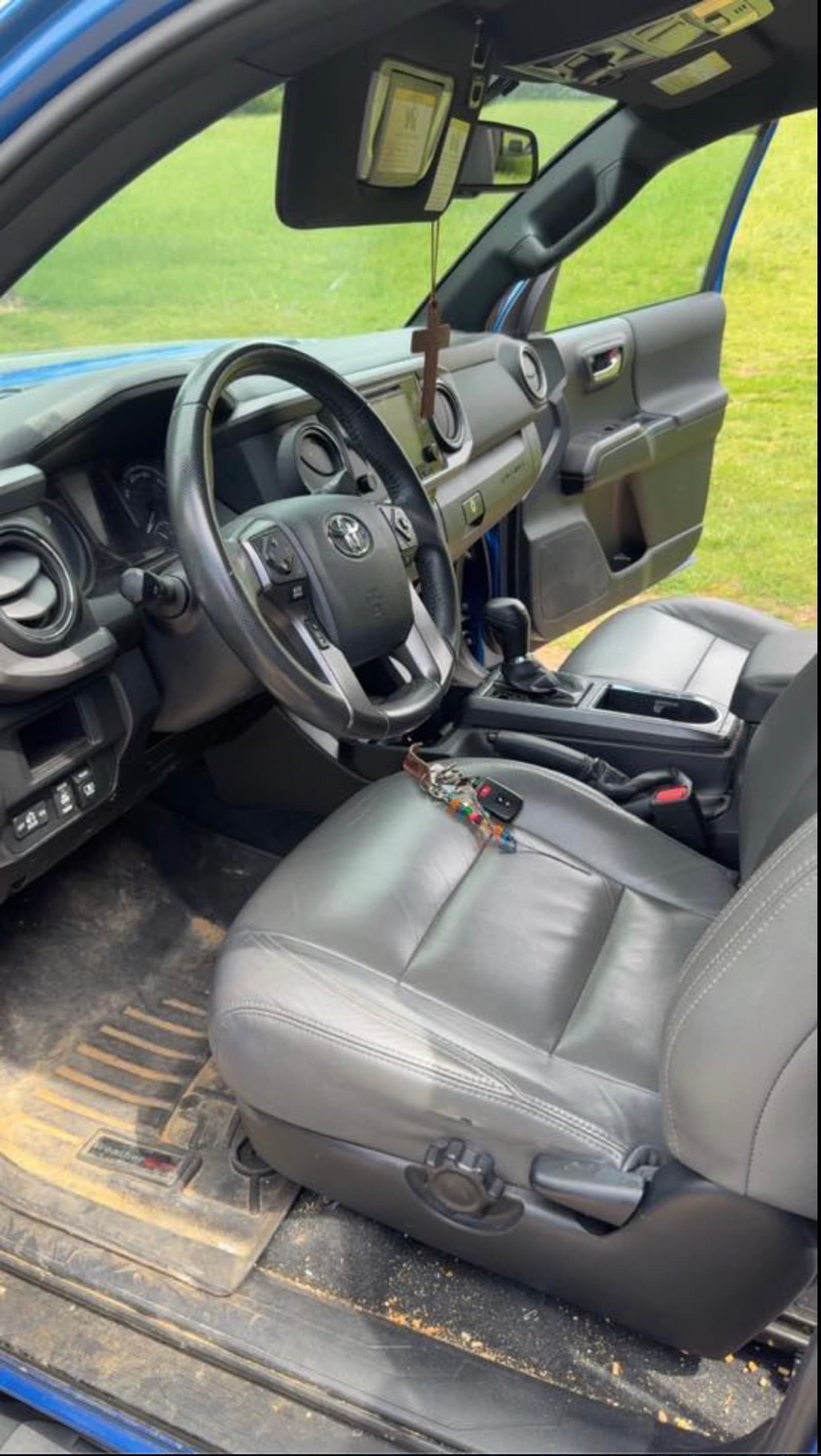 Toyota Tacoma interior before detail — dirty floor mat and grimy steering wheel